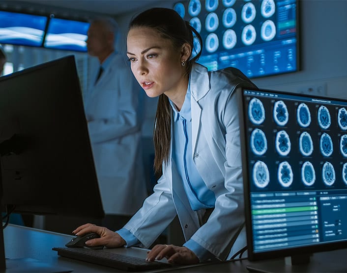 Image of a clinician in a white coat interacting with her computer